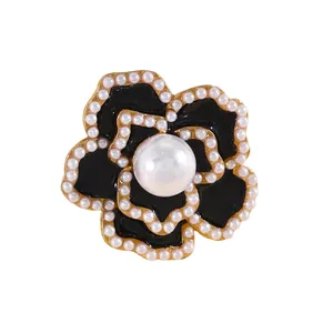 Primer plano detallado de un gemelo de flor en esmalte negro con perlas elegantes