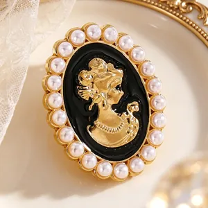 Detalle macro de un broche camafeo vintage con silueta dorada y borde de perlas decorativas