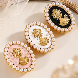 Detalle de gemelos vintage de camafeo con bordes de perlas en rosa, blanco y negro