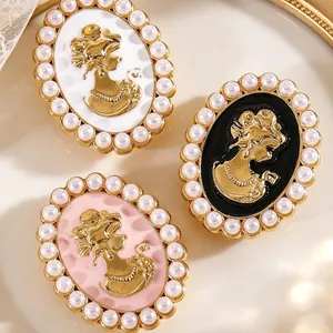 Primer plano de gemelos camafeo vintage con relieve dorado y bordes de perlas en tres colores