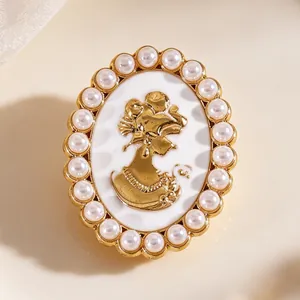 Detalle de un gemelo vintage con camafeo dorado y un elegante borde de perlas