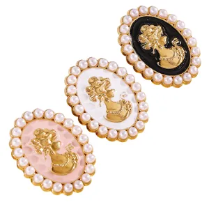 Detalle de gemelos tipo camafeo vintage con borde de perlas en negro, blanco y rosa.