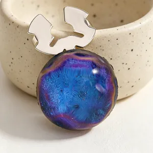 Primer plano de gemelos artísticos con esmalte nebulosa azul y base de flor plateada.