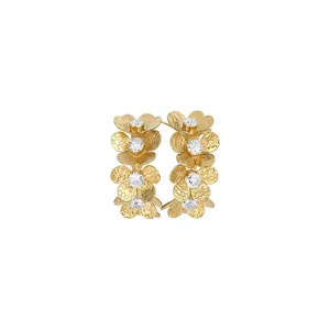 Elegantes pendientes de flores doradas con pétalos en capas y centros de circón brillante