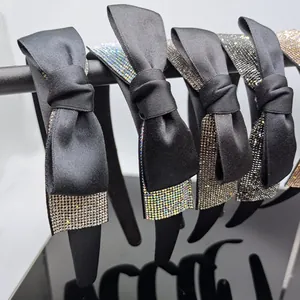 Dettaglio di strass colorati su cerchietti in raso nero con fiocchi sovradimensionati