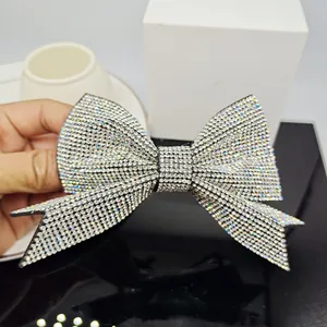 Close-up of a large sparkling rhinestone bow hair clip with intricate silver crystal inlay