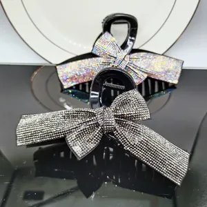 Detail of elegant black hair claws with shimmering rhinestones and large ribbon design
