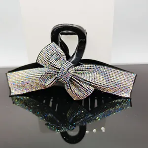 Macro shot of large black bow hair claw clip with colorful sparkling rhinestones