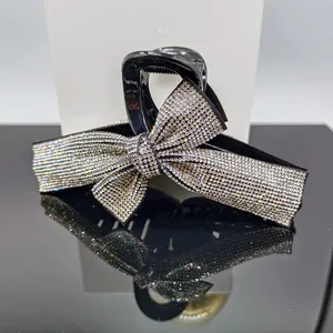 Macro shot of large ribbon bow hair claw clip with sparkling rhinestones and black finish