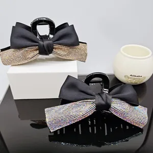 Detail of double-layer satin bow hair claw clip with rhinestones and black finish
