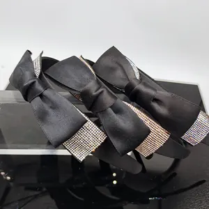 Set di tre cerchietti in raso nero con grandi fiocchi decorati con strass luccicanti