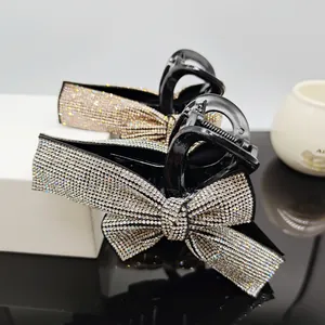 Close-up of elegant black hair claw clips with sparkling rhinestone bow tie detail