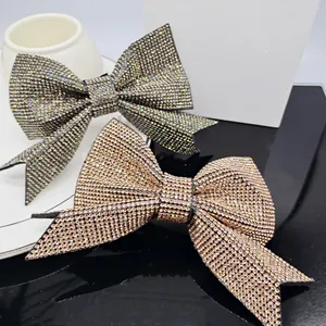 Detailed view of large sparkling rhinestone bow hair clips in silver and champagne gold