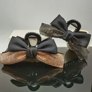 Detailed macro view of satin bow hair claws featuring elegant sparkling rhinestones