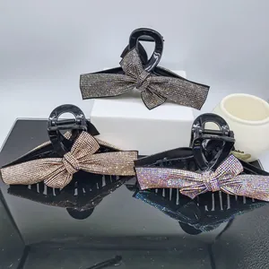 Detail view of large ribbon bow hair claws with sparkling rhinestones in three elegant colors