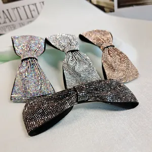 Barrettes à cheveux nuds avec strass brillants en noir, argent et doré sur un tissu doux