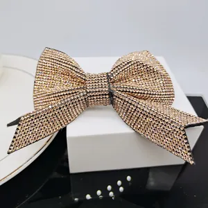 Macro shot of elegant champagne gold bow hair clip with full rhinestone inlay detailing