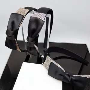 Cerchietto in raso nero con fiocco grande e strass colorati brillanti di tendenza