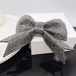 Close-up of sparkling grey rhinestone bow hair clip with luxury shimmering crystals