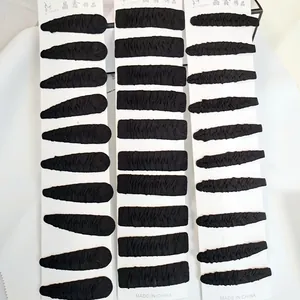 Detailed view of 30-piece black fabric covered snap hair clips set on white cards