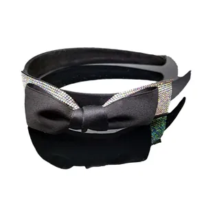 Dettaglio del cerchietto in raso nero con strass colorati e un fiocco decorativo