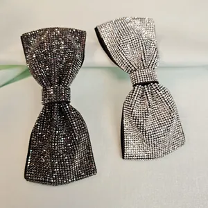 Détail de barrettes à nœud avec strass étincelants en noir et argent