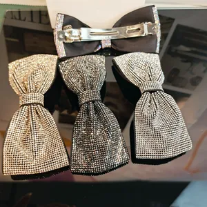 Détail de barrettes nœuds avec cristaux strass et clip à ressort métallique