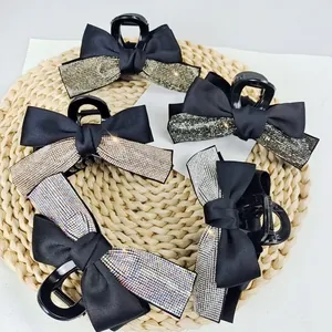 Grande pince à cheveux avec nœud en satin noir et strass sur un support en paille