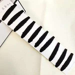 Close-up of 10 black fabric covered oval hair clips neatly arranged on a white display card