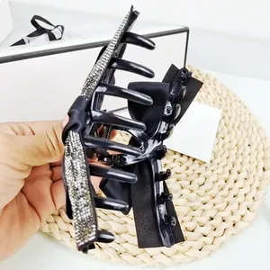 Grande pince à cheveux noire élégante avec nœud en satin et strass argentés brillants