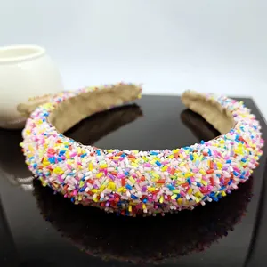 Chubby rainbow crystal padded headband with colorful bead embellishments on black mirror
