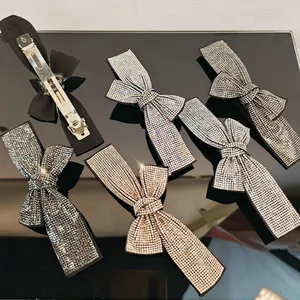 Close-up of sparkling rhinestone bow hair clips with silver and champagne gold finish