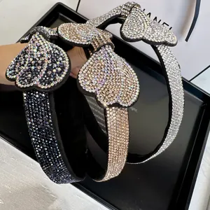 Detailed view of luxury heart-shaped rhinestone headbands in grey, gold and silver