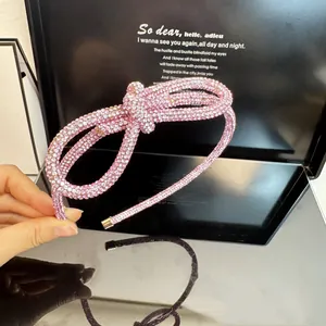 Detailed view of pink rhinestone knotted headband with sparkling crystal bow design