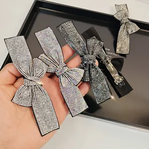 Close-up of four sparkling crystal bow hair clips with silver-tone metal spring duckbill clips