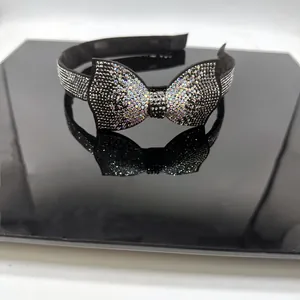 Détail d'un élégant serre-tête noir avec nœud en strass brillants sur un support miroir