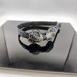 Macro detail of high-end black crystal bow headband with shimmering AB rhinestones