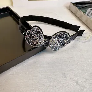 Elegant black fabric headband with oversized rhinestone bow and colorful AB crystals