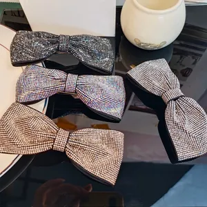 Détails de quatre barrettes à nœuds en strass disponibles en plusieurs couleurs brillantes