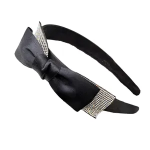 Dettaglio cerchietto in raso nero con fiocco decorato da strass argentati brillanti