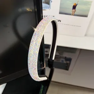 Close-up of luxury headband featuring iridescent rhinestones and white leather edge