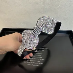 Close-up of luxury rhinestone bow headband with shimmering crystals on black fabric