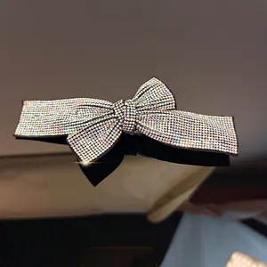 Macro shot of shimmering rhinestones on a bow-shaped hair clip with reflections