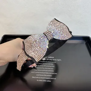 Détail d'un serre-tête nœud élégant orné de cristaux brillants sur du velours noir