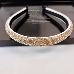 Detalle de diamantes champagne en diadema de lujo blanca y negra sobre bandeja negra