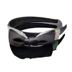 Elegante cerchietto nero in nastro con strass scintillanti e fiocco su sfondo bianco puro