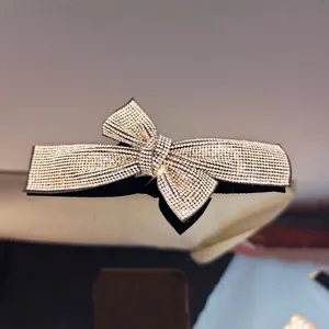 Macro view of crystal bow hair clip featuring shimmering rhinestones and black base