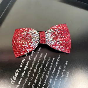 Détail d'un serre-tête nœud en strass rouge et argent avec motif scintillant