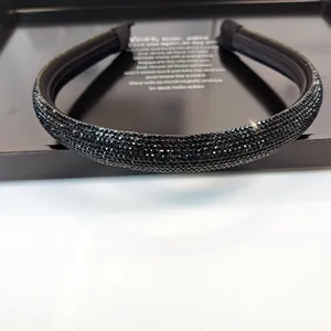 Primer plano detallado de una diadema de lujo con pedrería negra y puntas de tela acanalada