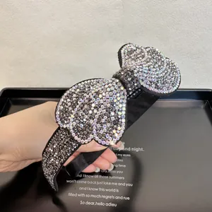 Macro shot of elegant black velvet headband featuring double bow with sparkling rhinestones